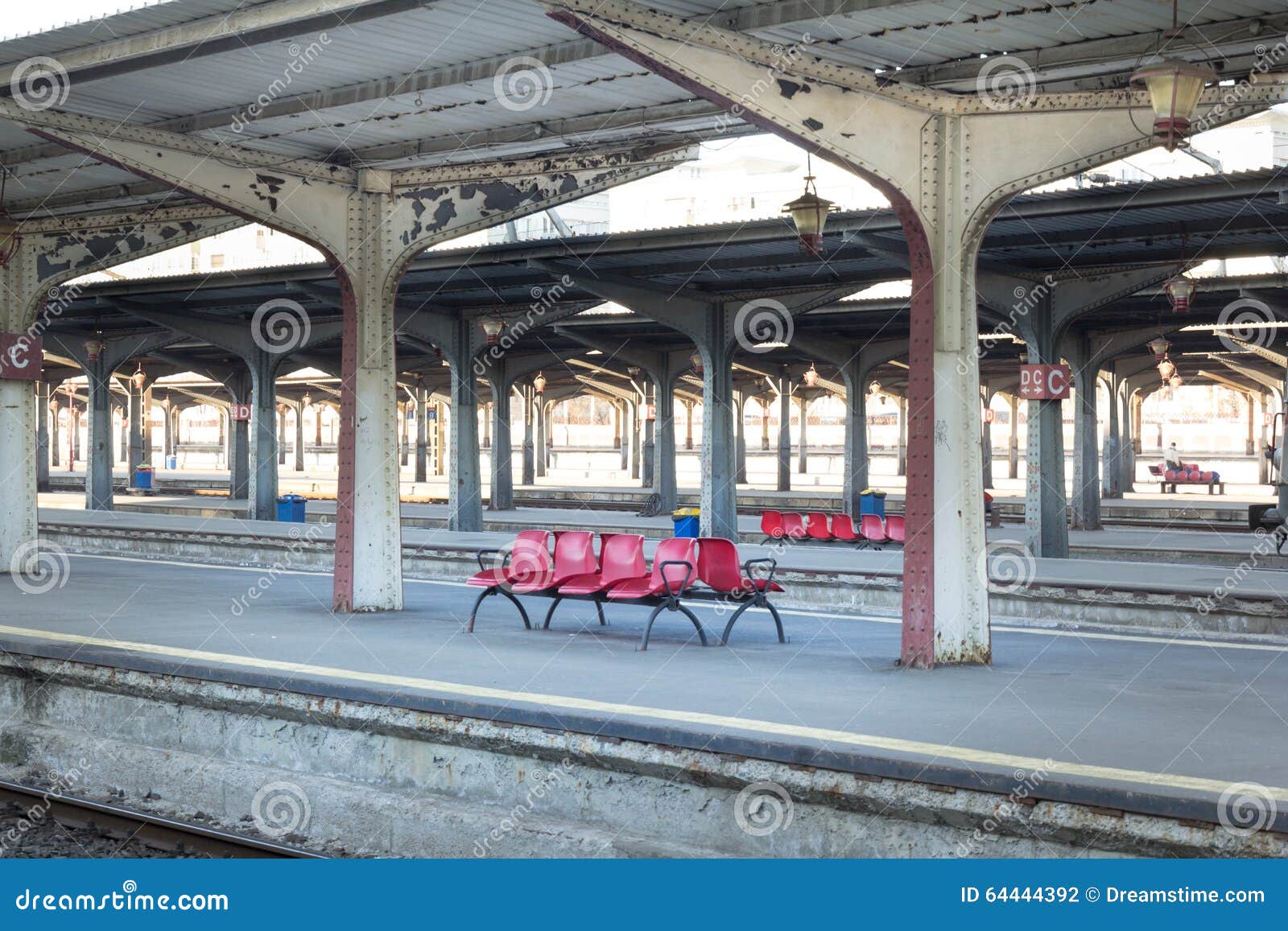 Sedie rosse in una stazione ferroviaria rumena con le colonne simmetriche