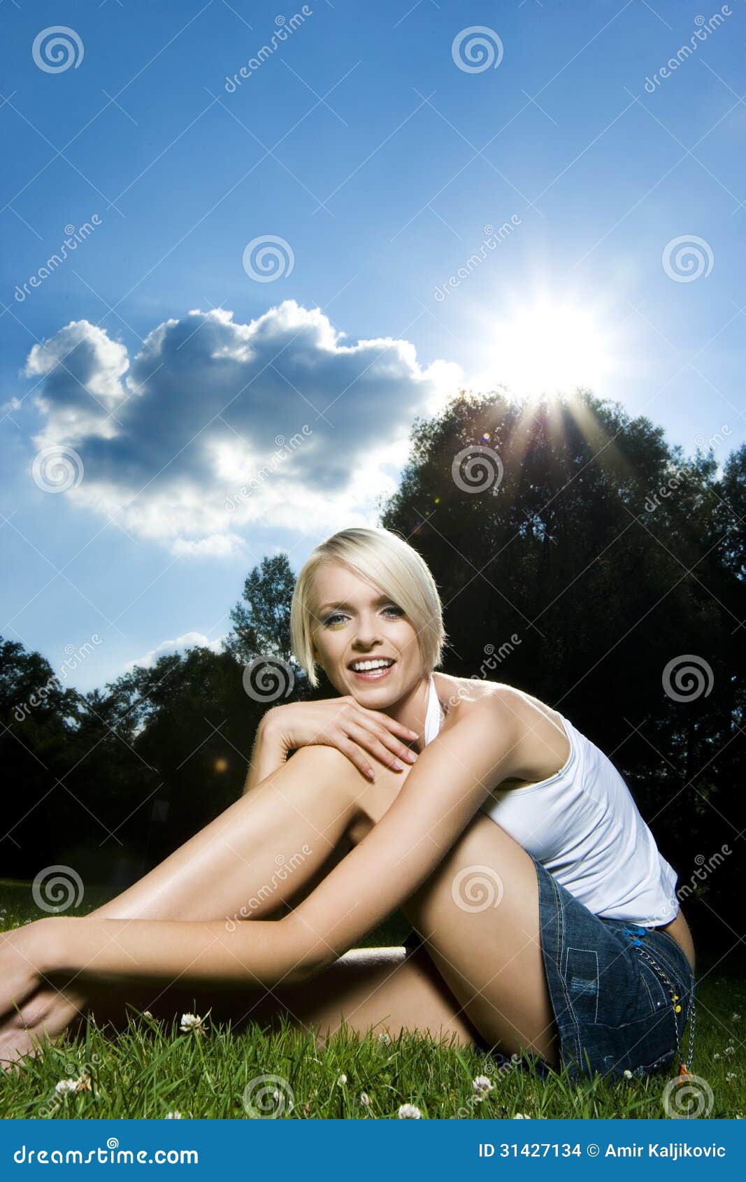 Seductive Blond Woman Sitting On A Grass Field Stock Photo 