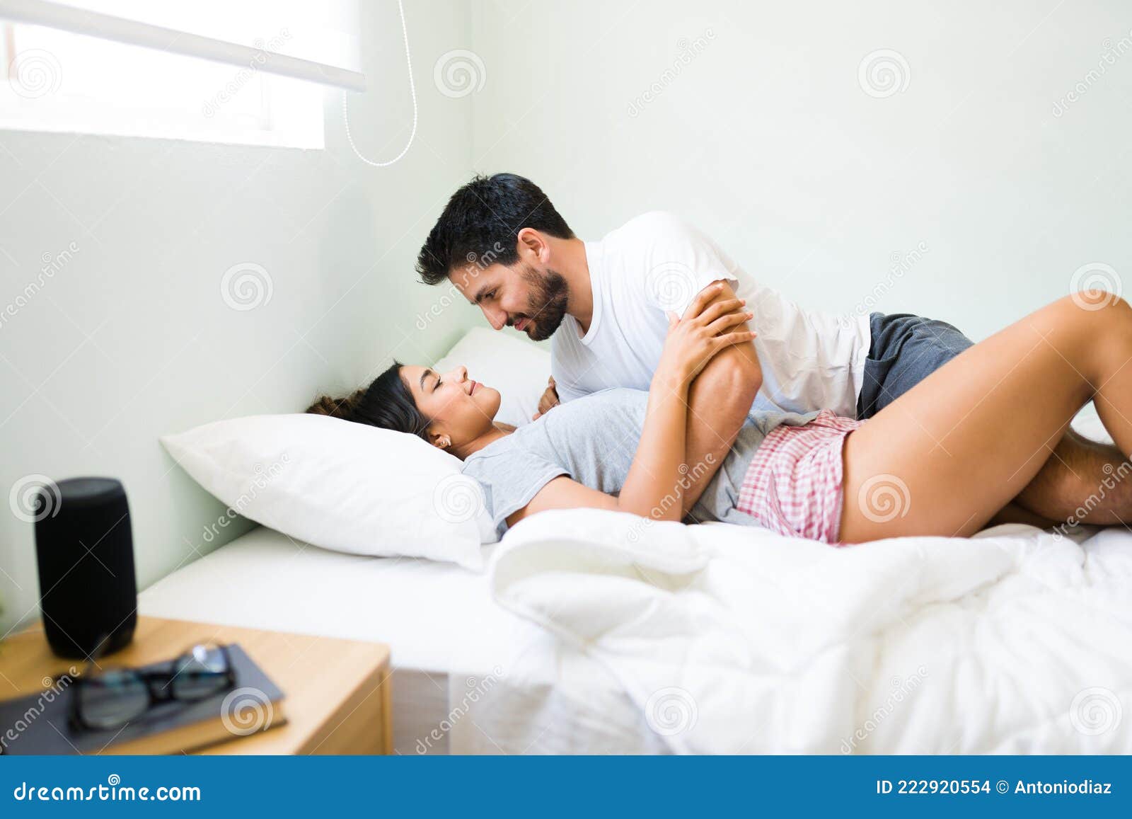 Seductive Boyfriend Smiling To His Girlfriend in Bed Stock Photo