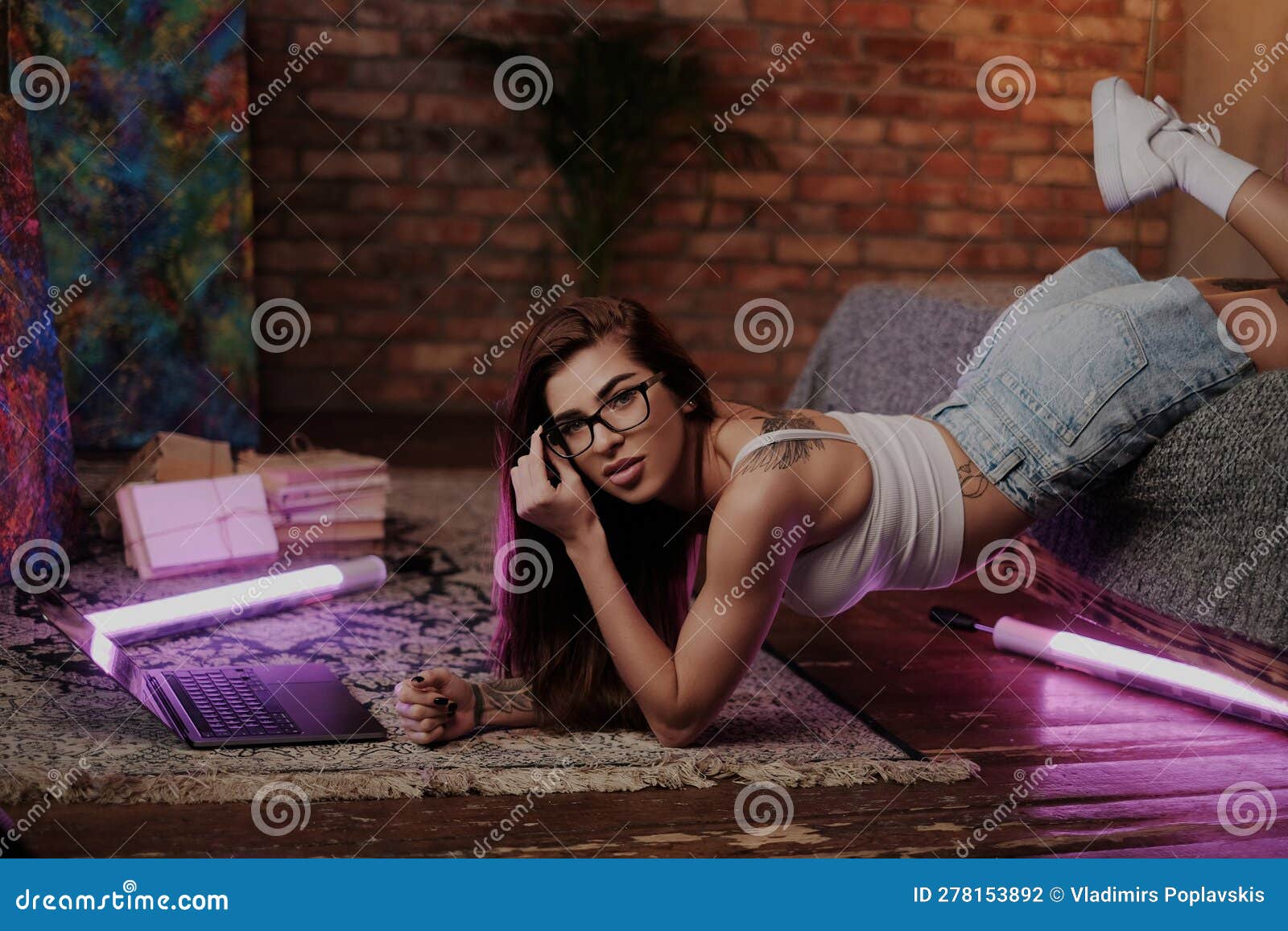 Seductive Girl Tattooed Body And Glasses Using Laptop On Sofa Stock