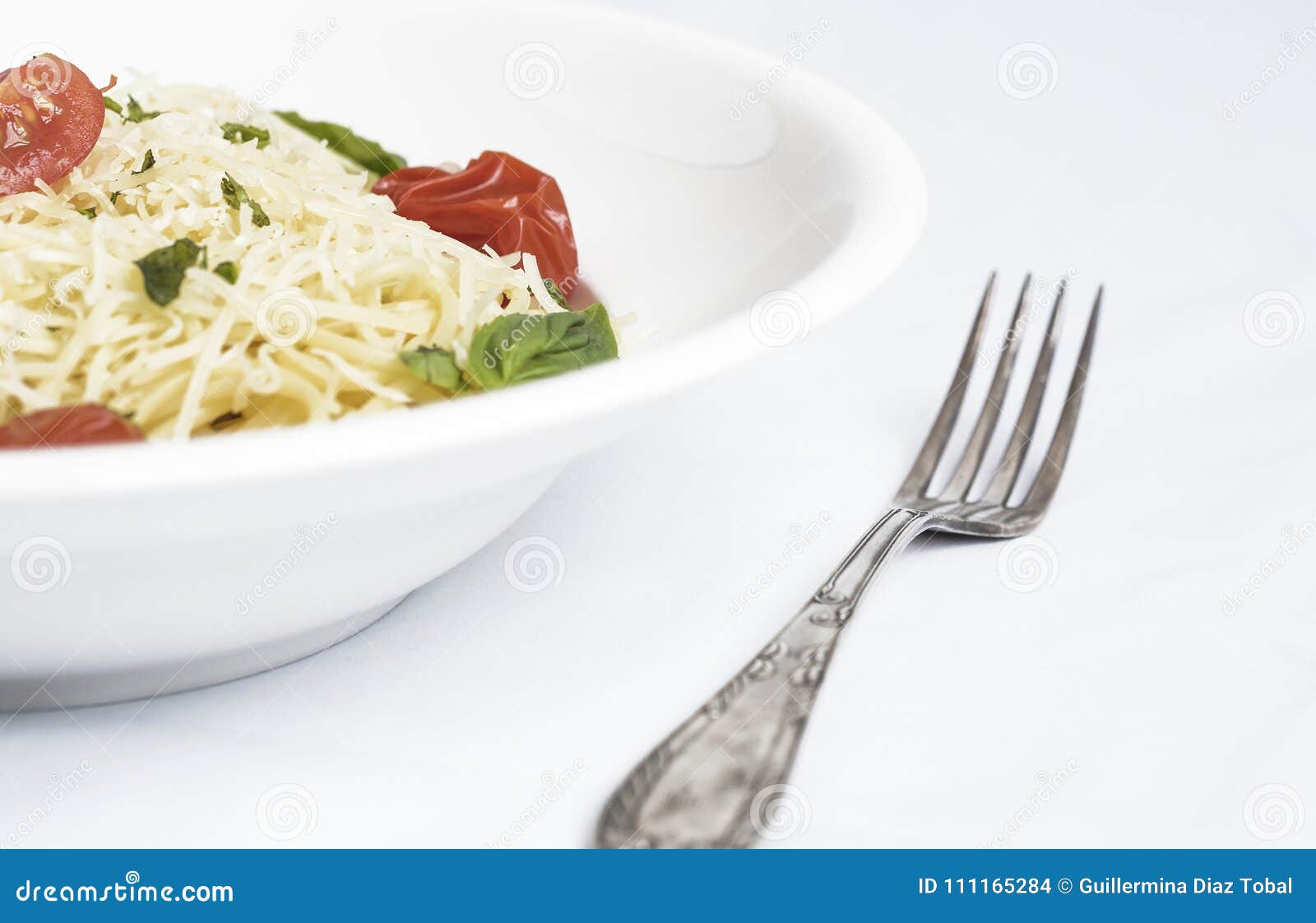 plate of spaghetti with cherry tomatoes, basil and grated cheese