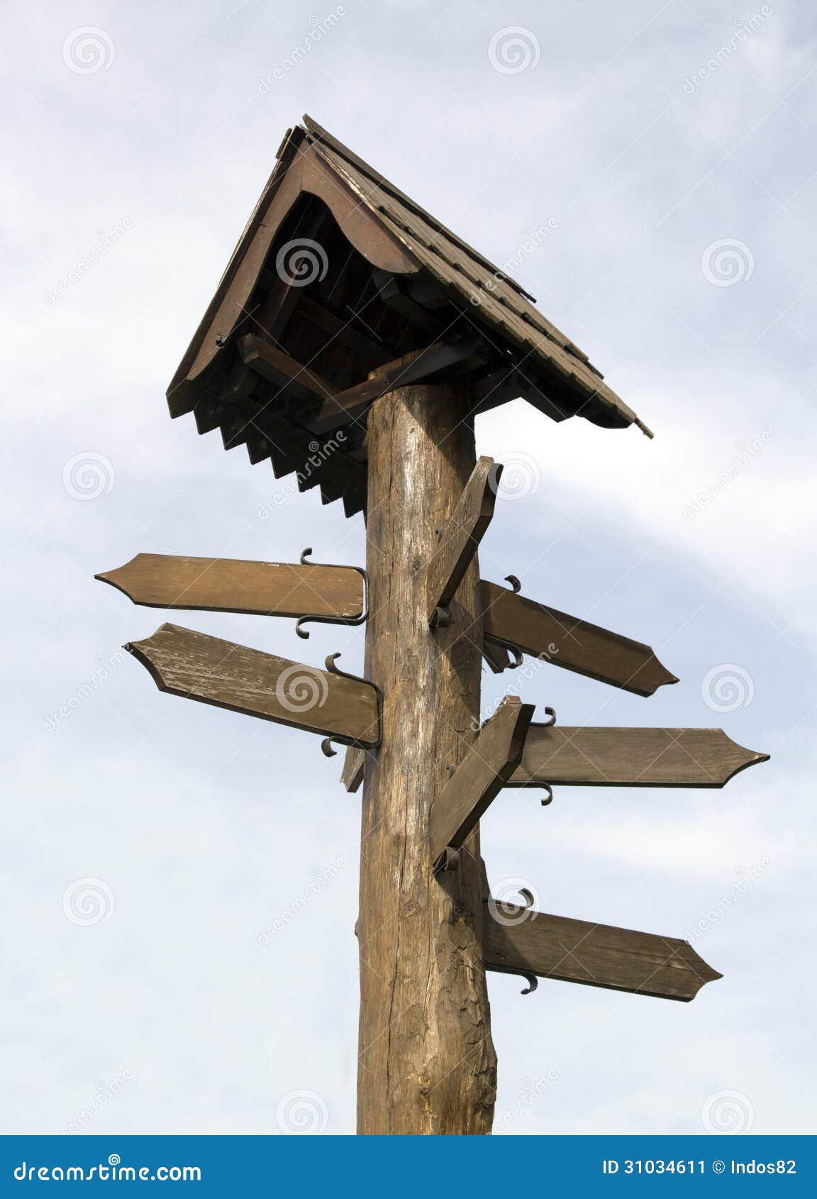 Segno di legno della guida. Un cartello di legno isolato su un cielo nuvoloso