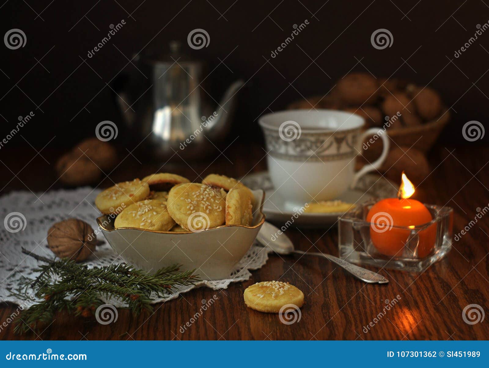 Selbst gemachte Kekse mit Samen des indischen Sesams, Walnüssen, Kerzen und Tellern auf einem Holztisch Noch Leben 1