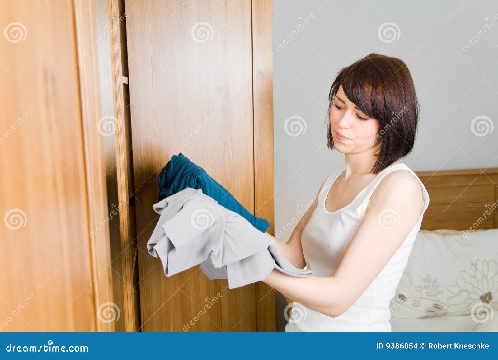 Indecision woman choosing outfit in clothes closet Stock Photo by