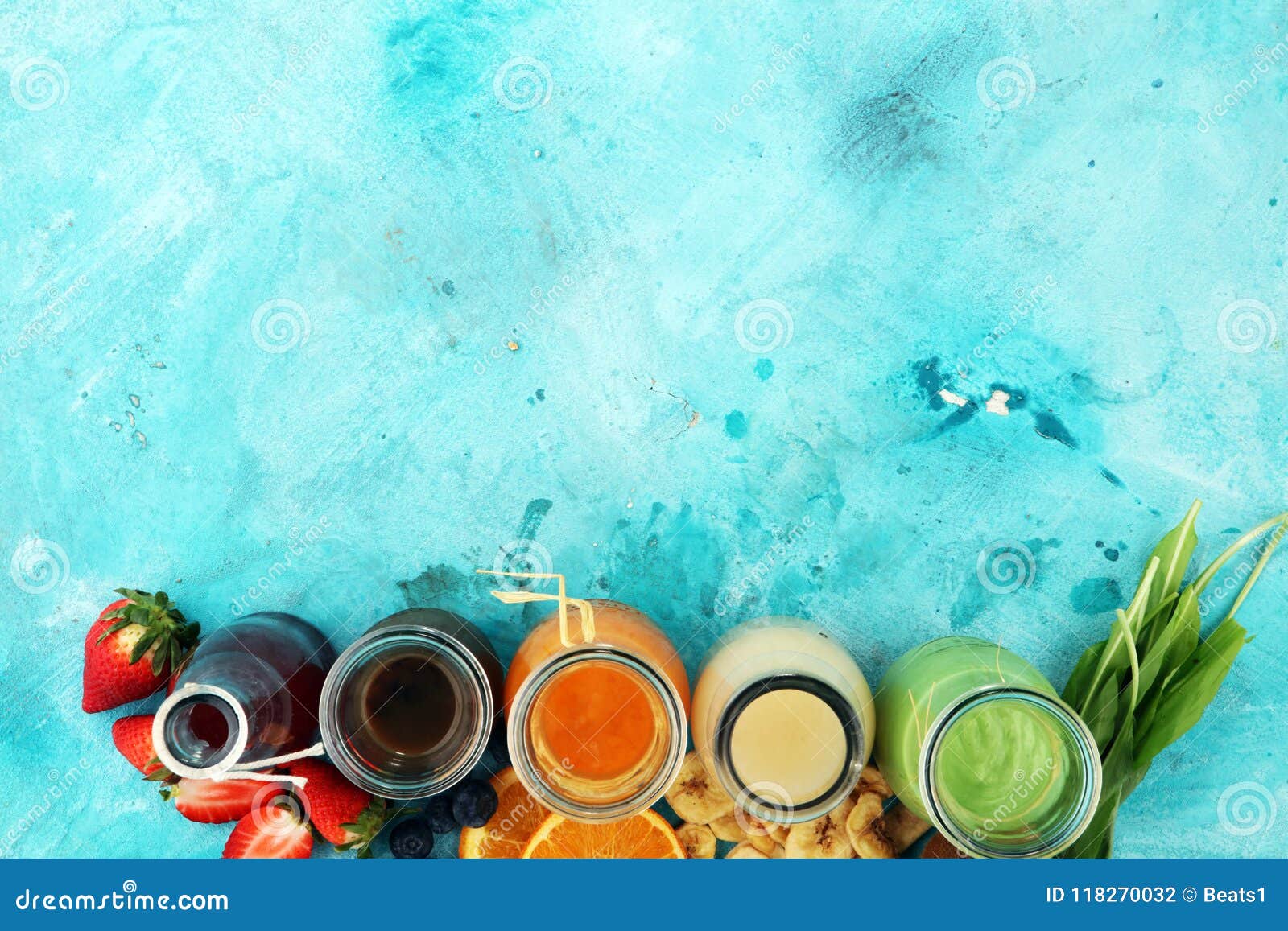 Selection of colorful smoothies on rustic background with vegetables and fruits