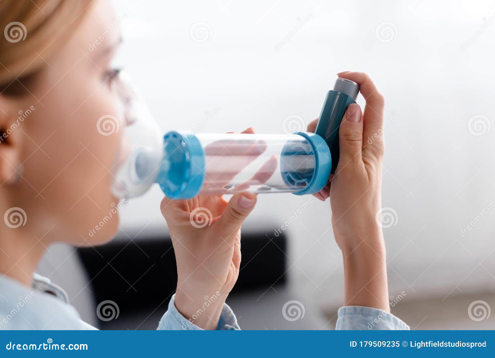 focus of asthmatic woman using inhaler