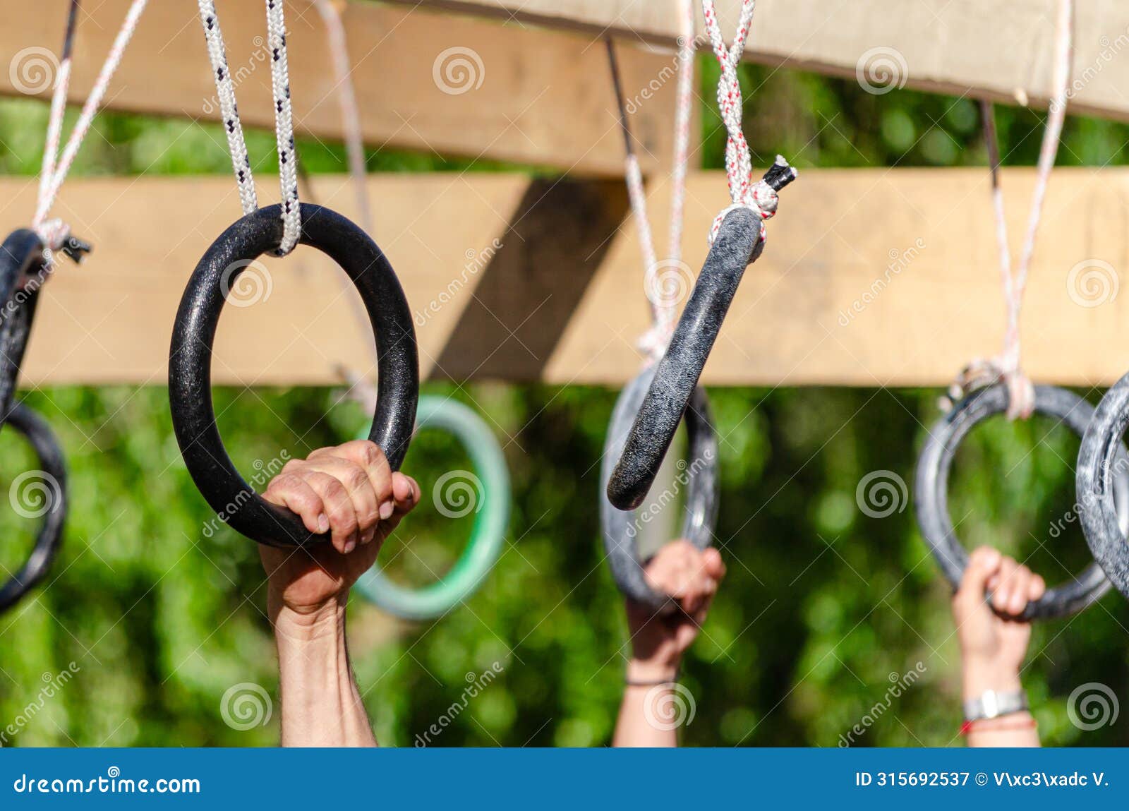 selective focus, athletes hands at a hanging obstacle at an obstacle course race, ocr