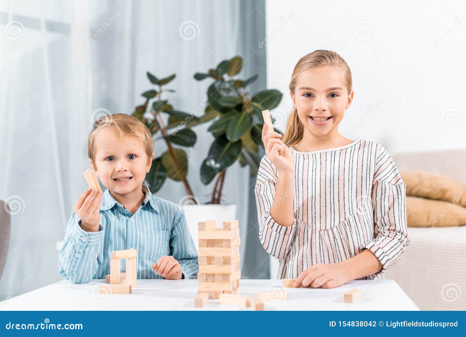 selective focus of happy adorable children playing blocks wood tower game