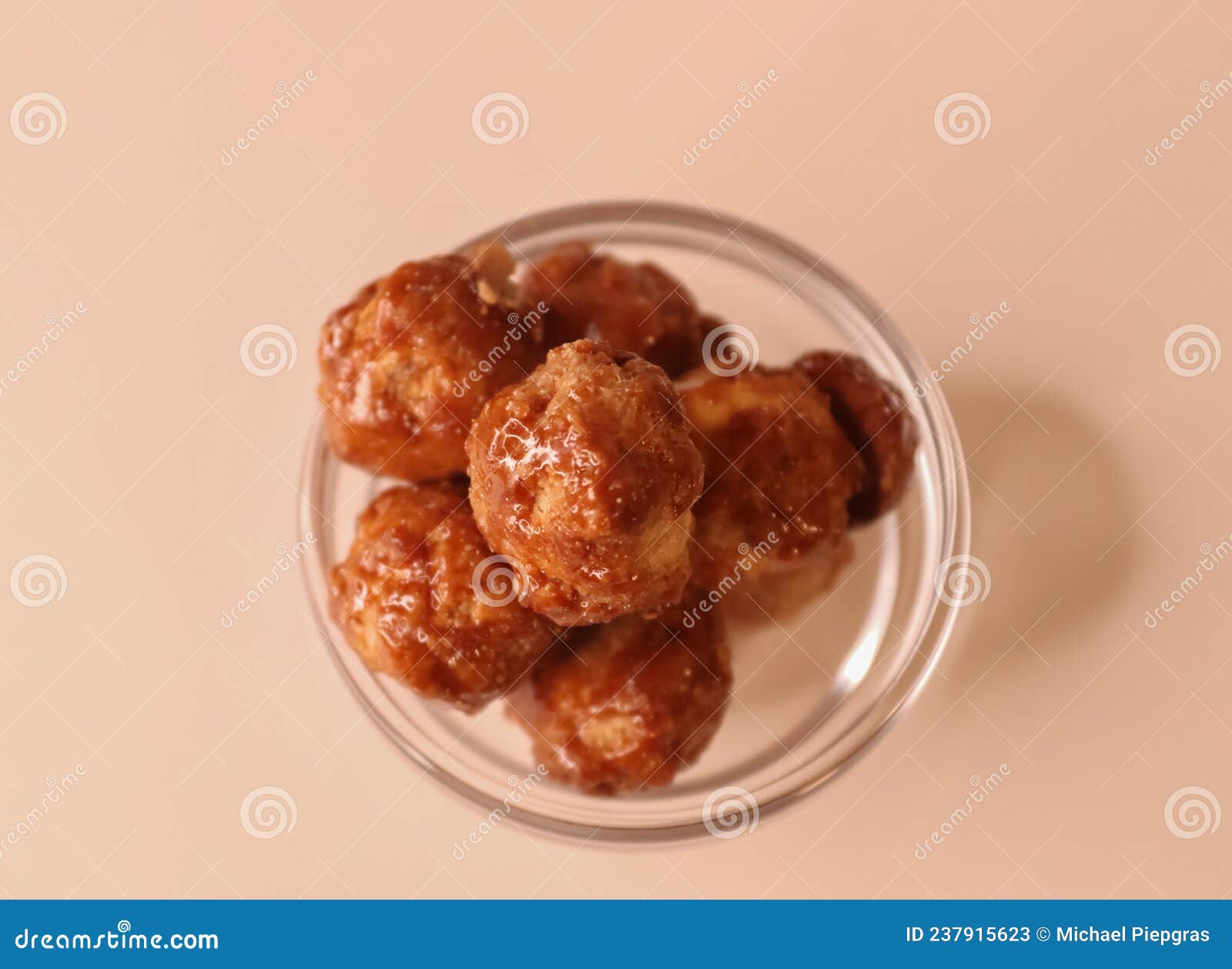 selective focus of many candied macadamia nuts spinning in a small bowl