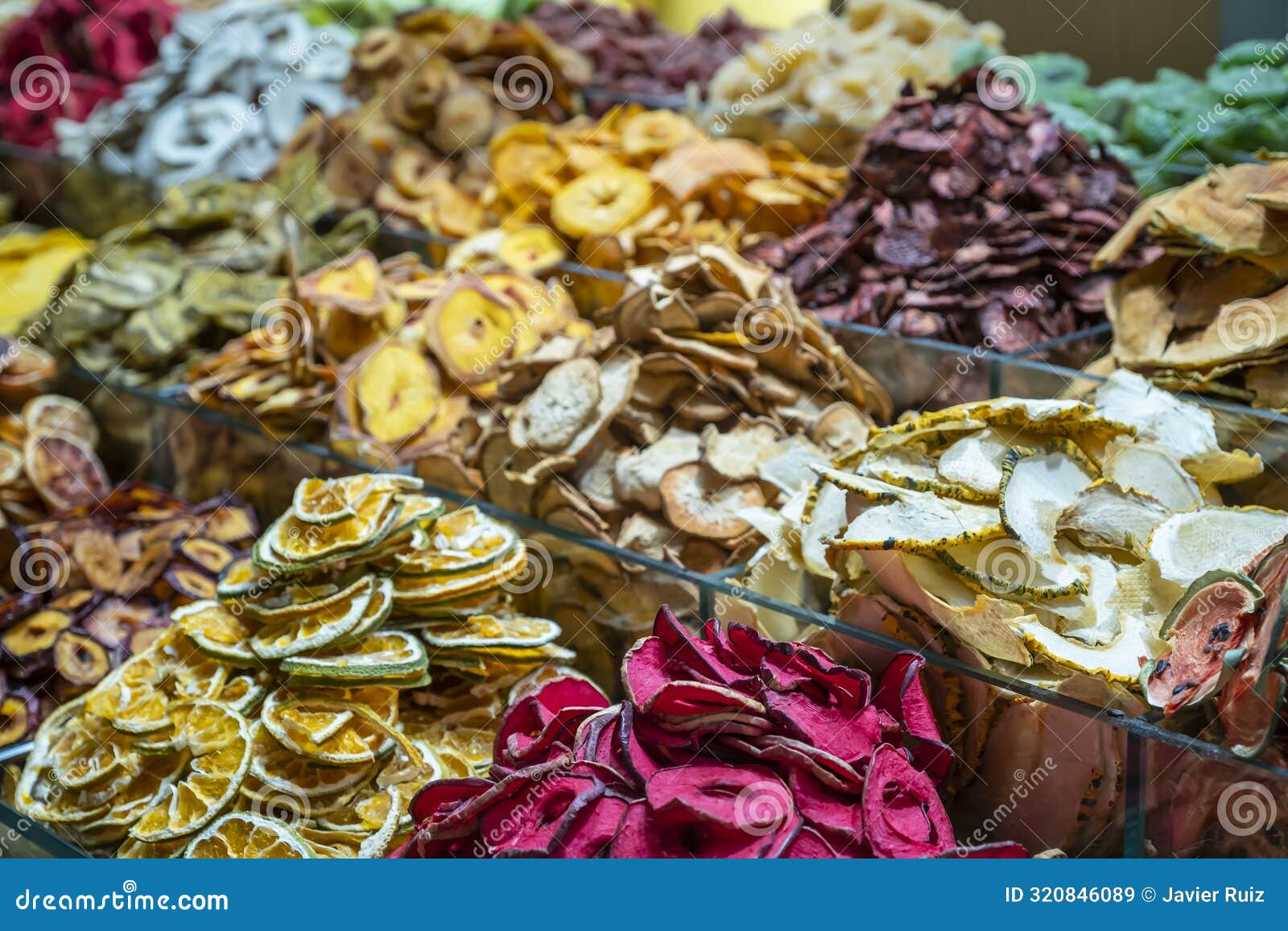 selective focus on a shelf full of dried fruits of different types and colours, oranges, apples, watermelons, pineapples, lemons,