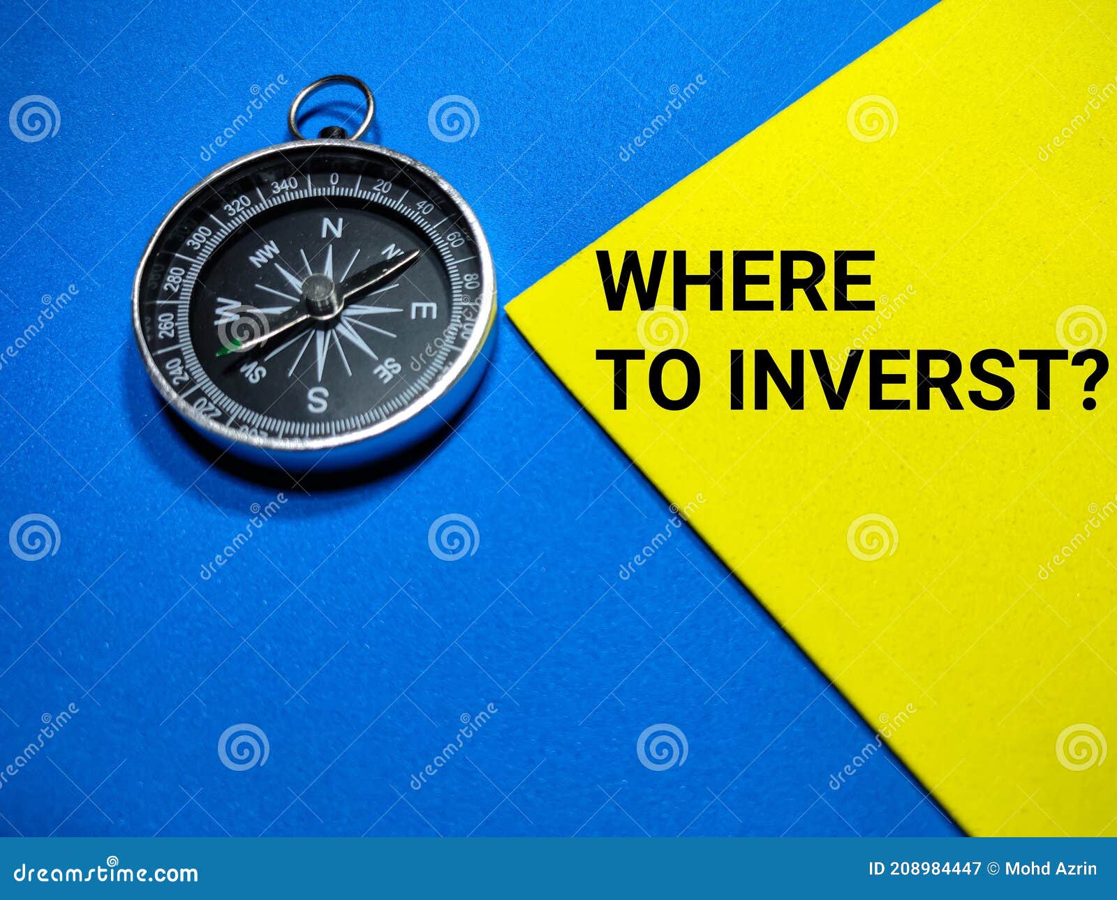 selective focus.text where to inverst with compass on a blue and yellow background.