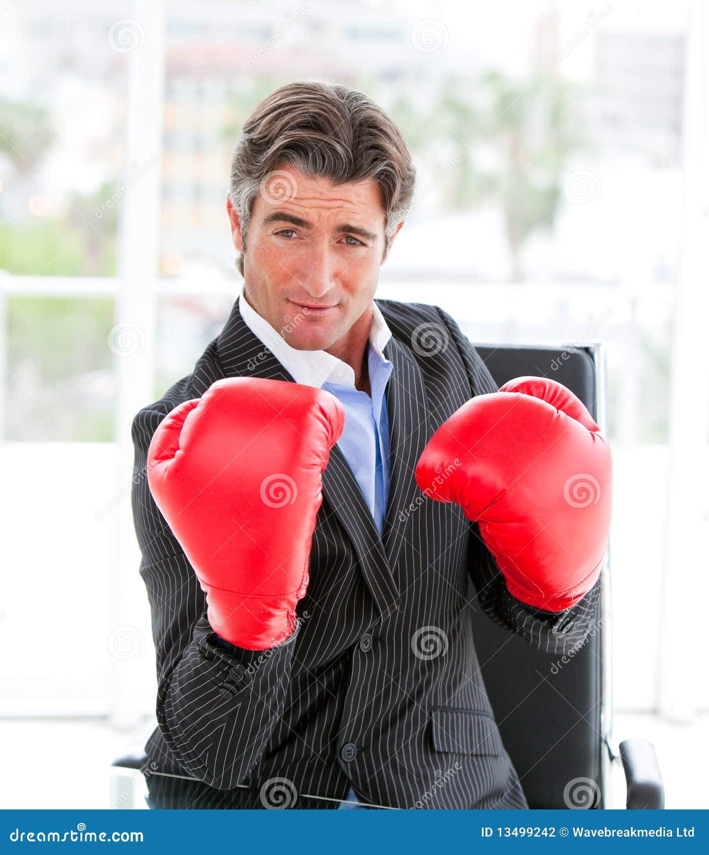 self-assured businessman wearing boxing gloves