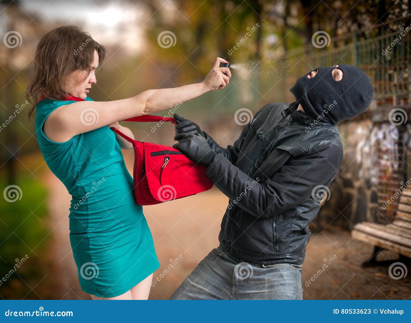 self defense concept. young woman was attacked by man in balaclava is using pepper spray