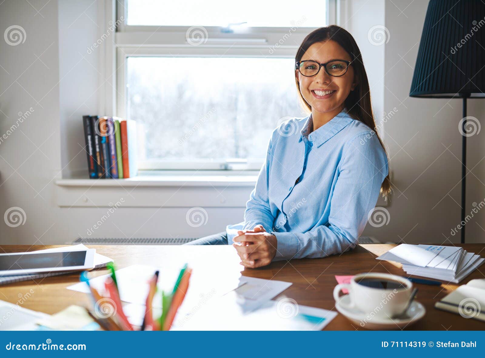 self employed woman wearing glasses at desk