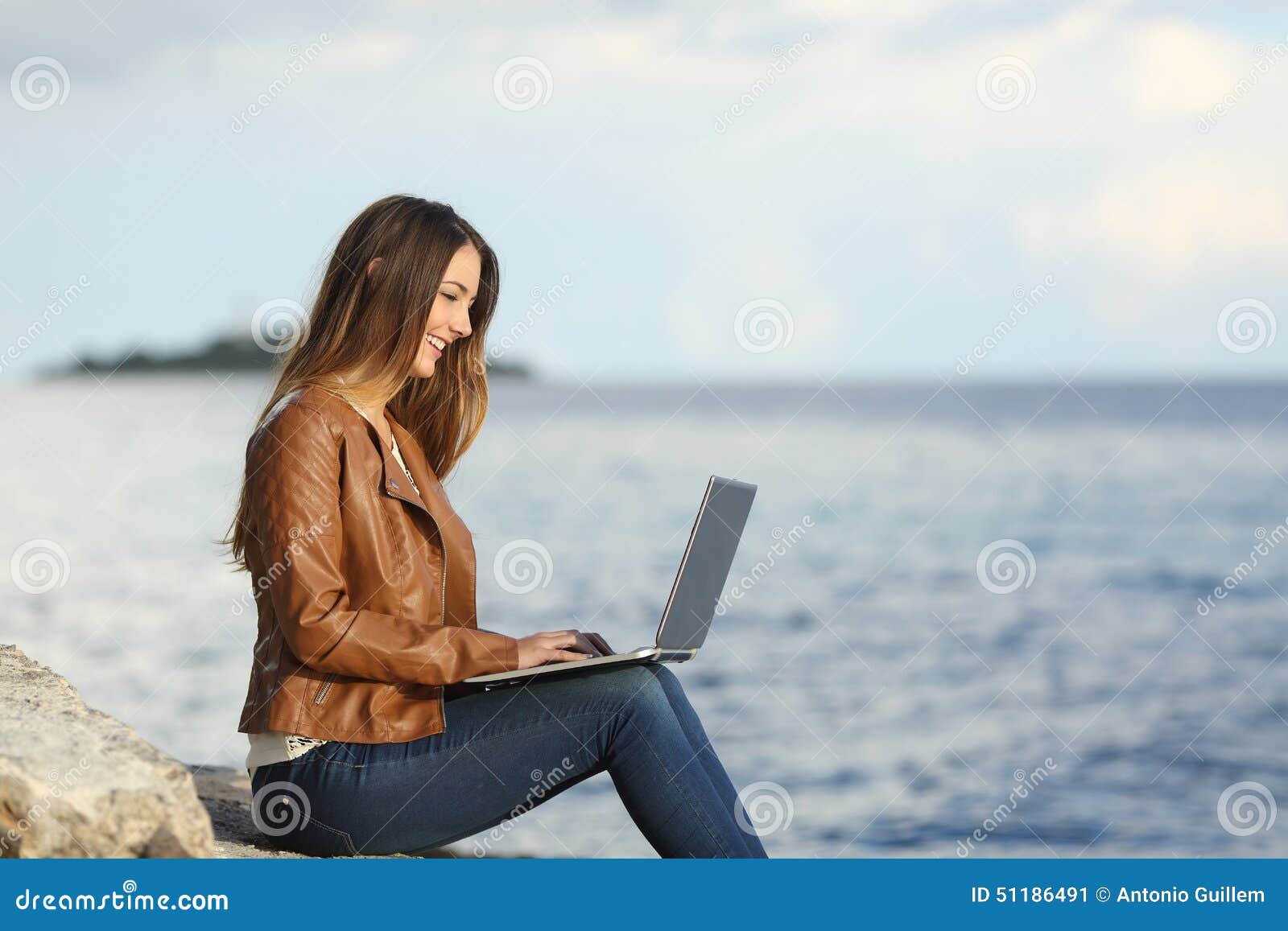 self employed woman working with a laptop on the beach