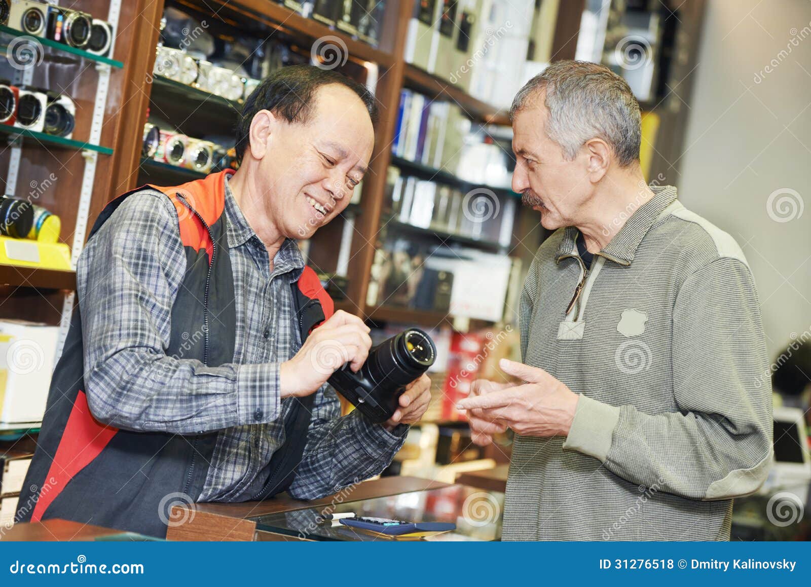 seller demonstrating photo camera to buyer