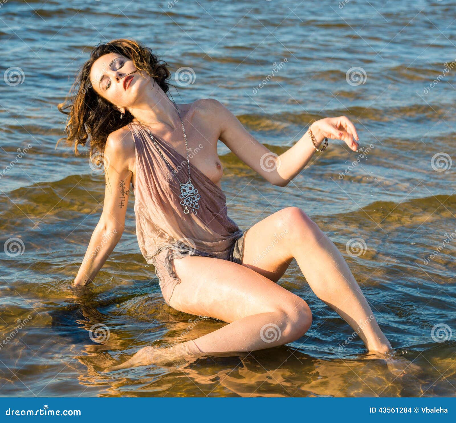 Seminude girl at the beach stock photo