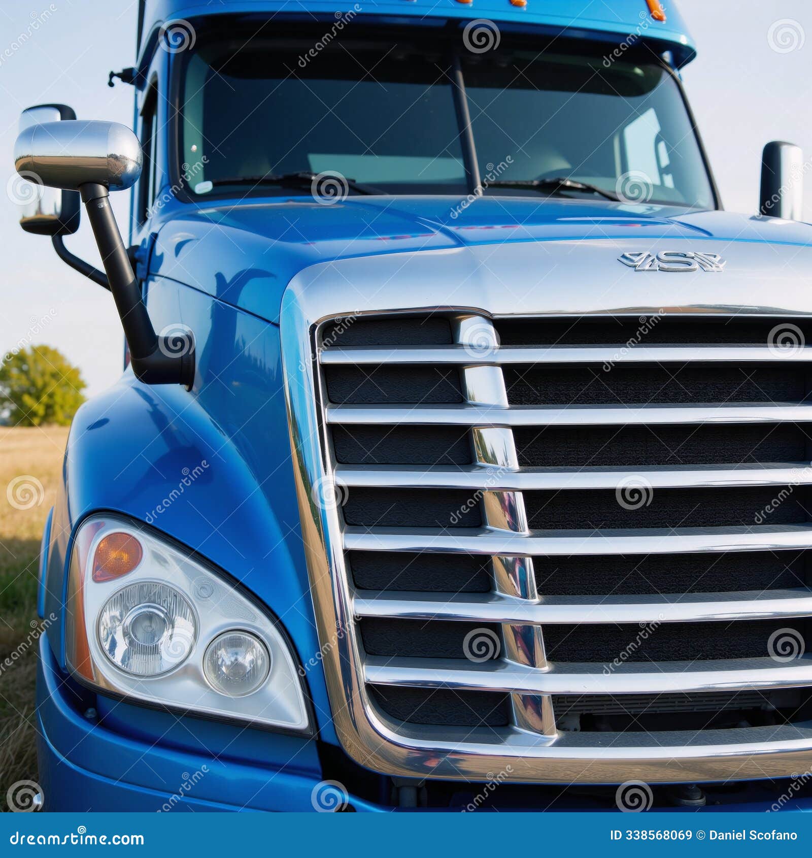 a semitruck featuring blue and white color scheme prominently displaying its grille and headlights