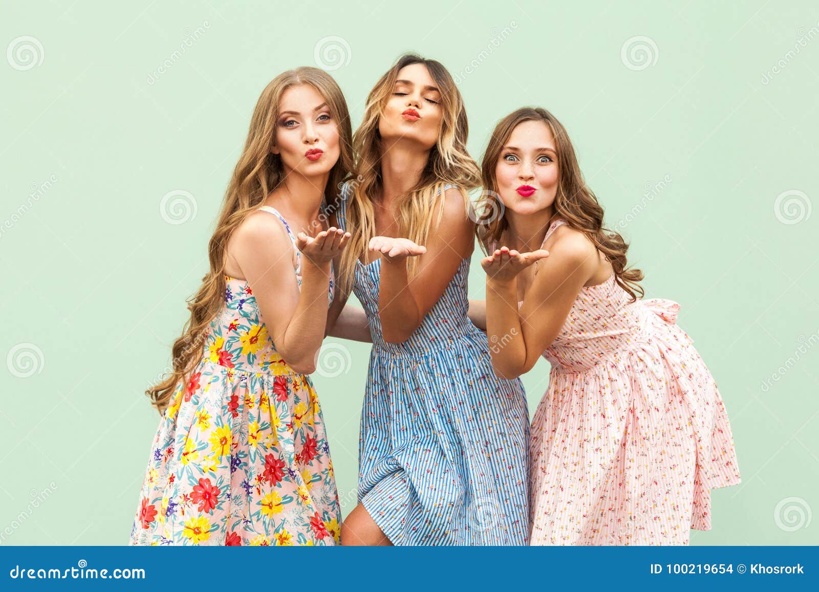 sending air kiss three best friends posing studio wearing summer style dress against green background sending air kiss three 100219654