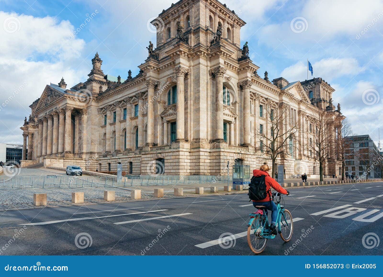 Senhora em bicicleta Reichstag edifício com pavilhões alemães Berlim. Berlim, Alemanha - 8 de dezembro de 2017: Moça de bicicleta na arquitetura do edifício Reichstag com Bandeiras Alemãs em Berlim, capital da Alemanha no inverno na rua Parlamento alemão