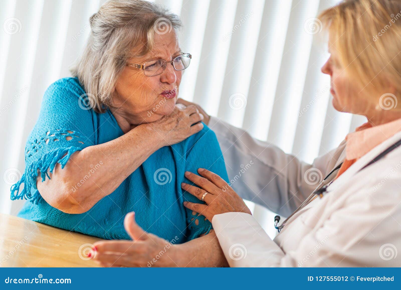 senior adult woman talking with female doctor about sore shoulder