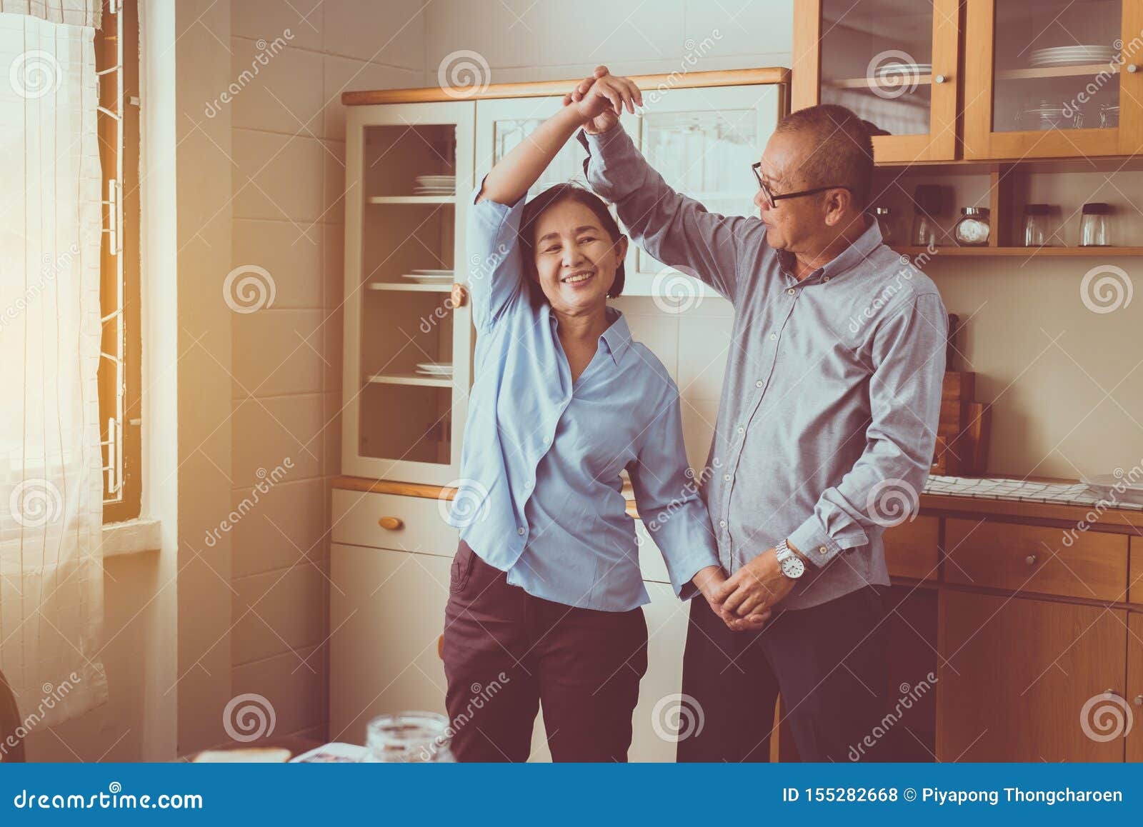 senior asian couple dancing enjoying at home together,having fun and love live forever