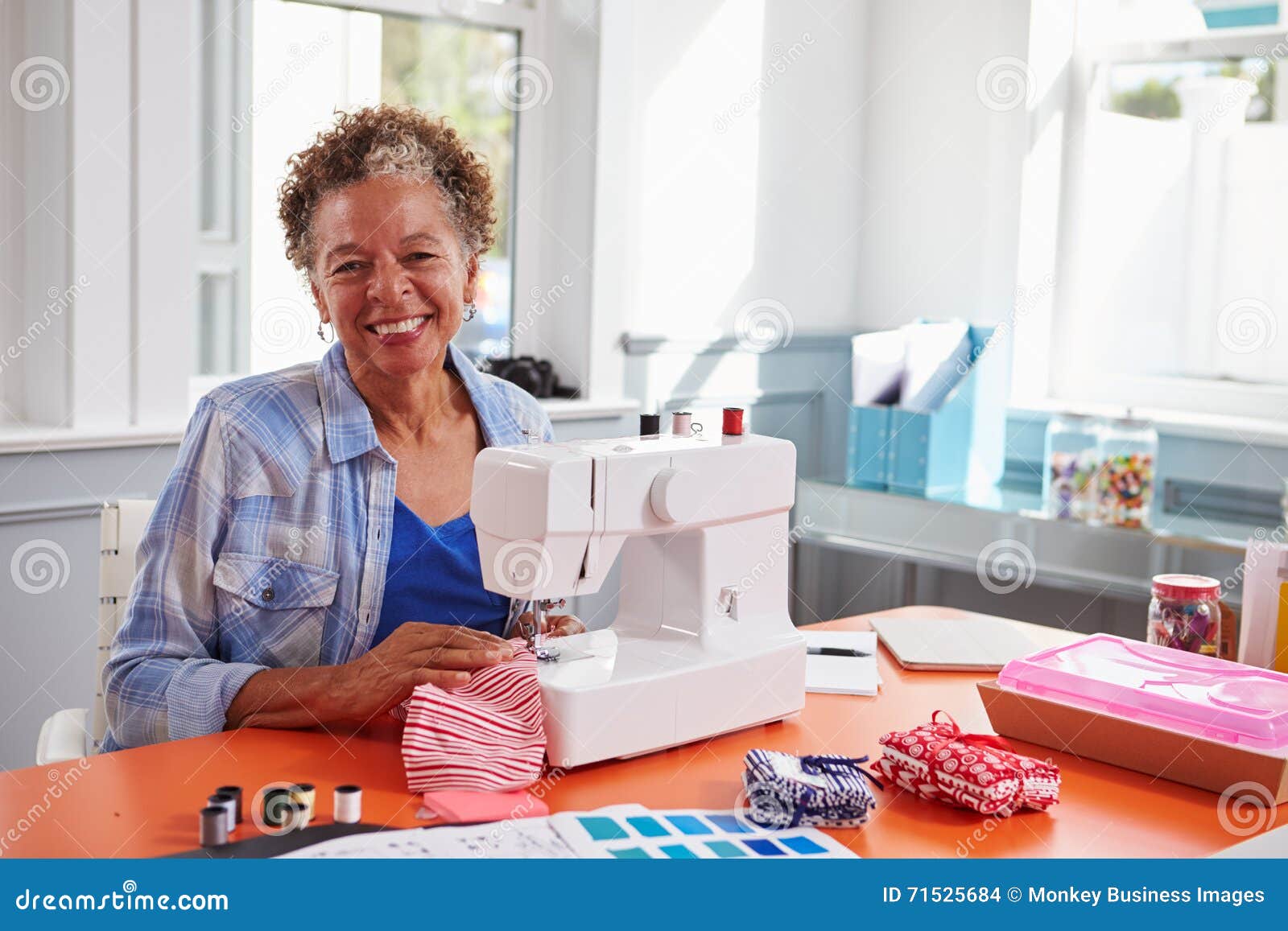 Senior Black Woman Using a Sewing Machine Looking To Camera Stock Photo