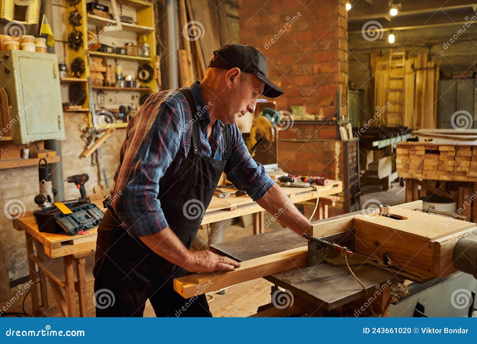 Senior Carpenter in Uniform Works on a Woodworking Machine at the