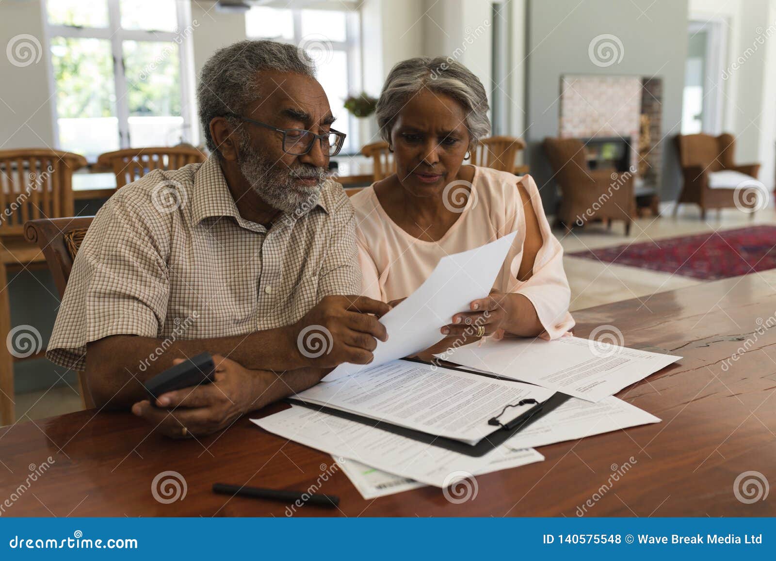 senior couple discussing over invoices at home