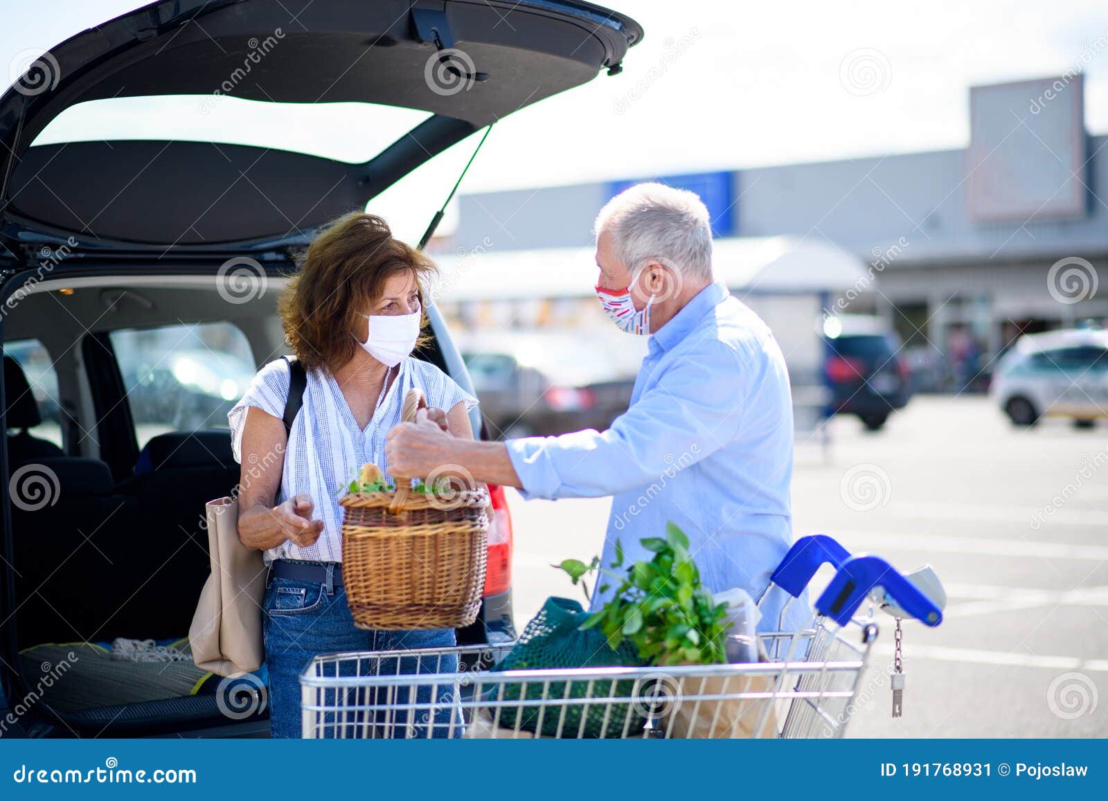 Senior Couple with Face Masks Putting Shopping in Car Outside ...