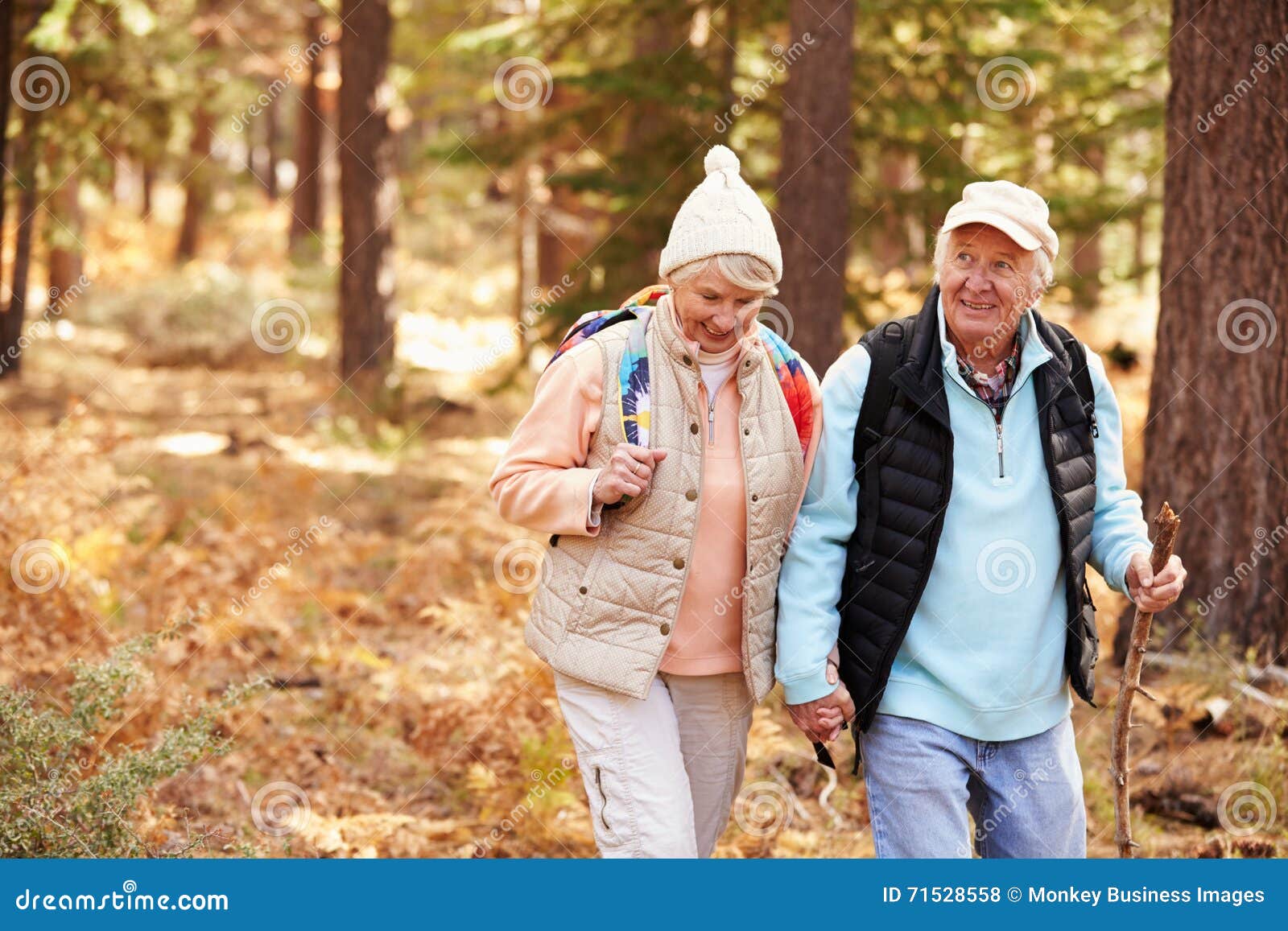 senior couple hold hands hiking in a forest, california, usa