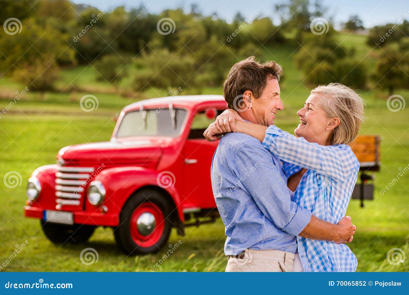 Senior Couple Hugging, Vintage Styled Red Car, Sunny Nature Stock Photo ...