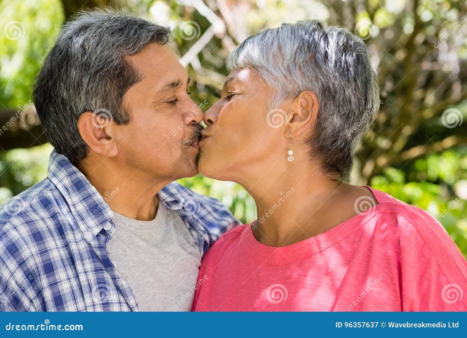 Senior Couple Kissing Each Other In Garden Stock Image