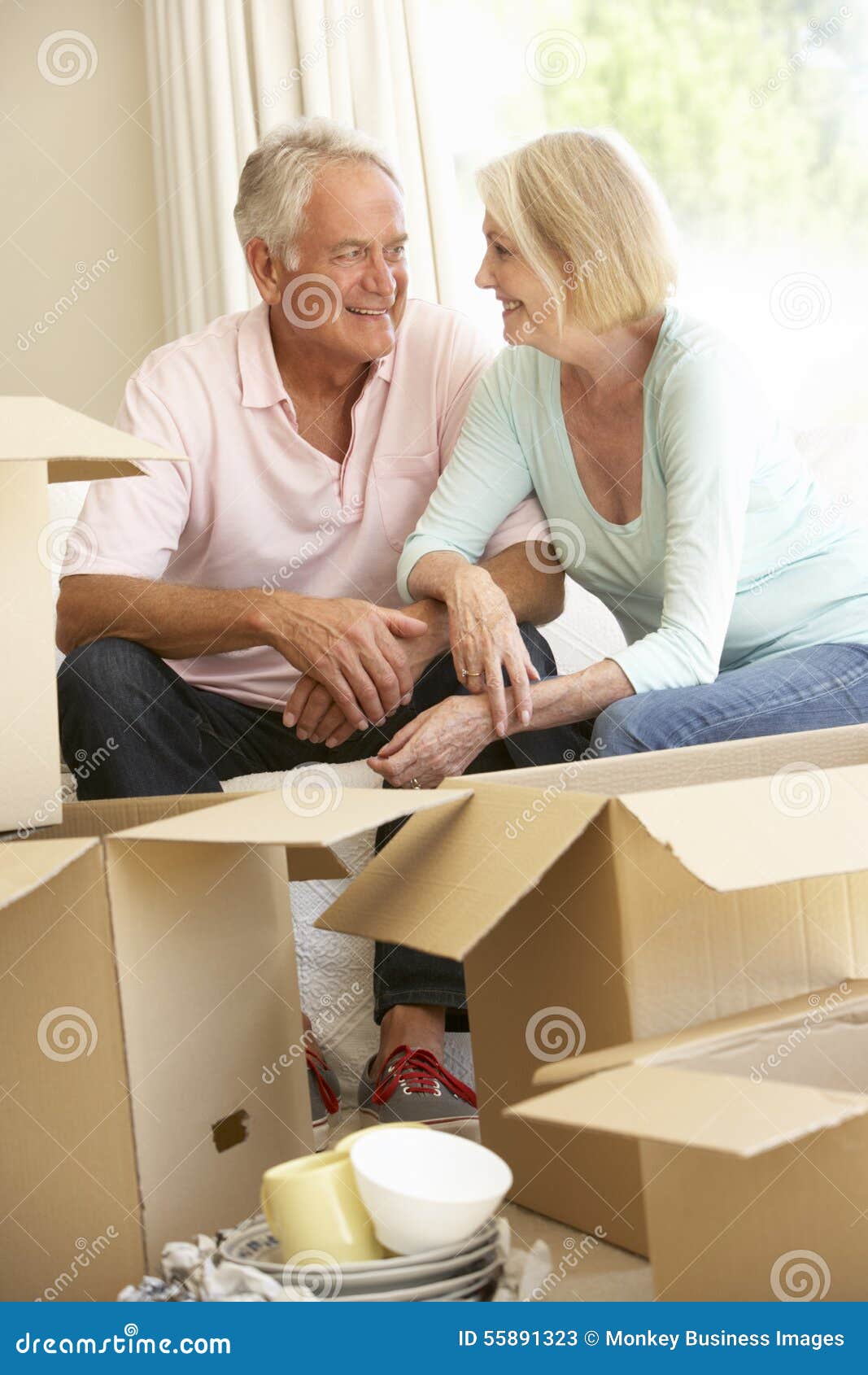 senior couple moving home and packing boxes
