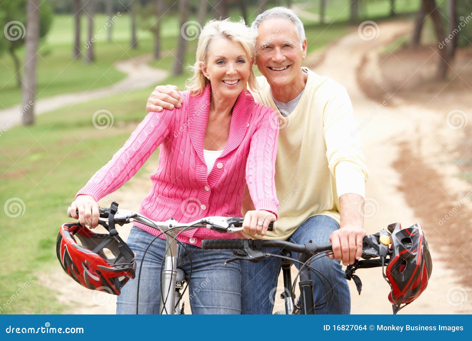 senior couple riding bicycle in park
