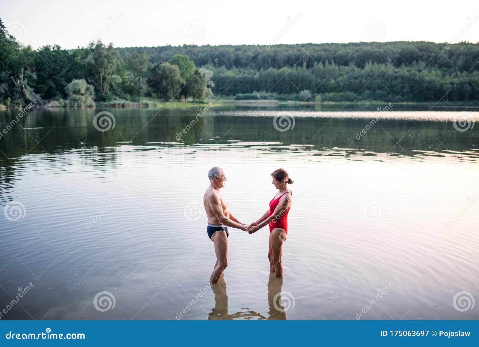 Senior Couple In Swimsuit Standing In Lake Outdoors Before Swimming