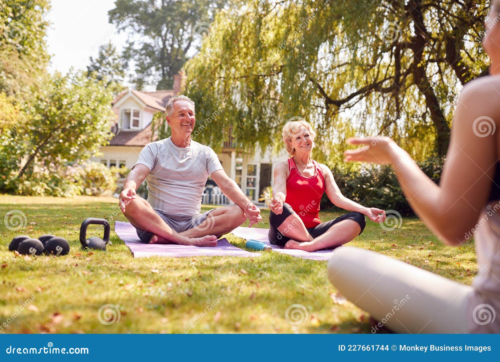 Senior Couple Taking Part in Private Yoga Class with Teacher in Garden ...