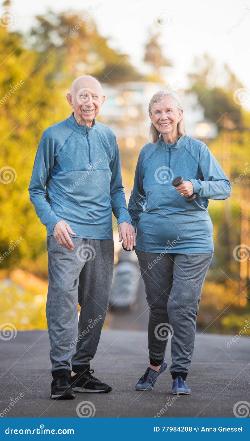 Senior couple walking along street on hill. Happy male and female mature couple walking along street with steep hill