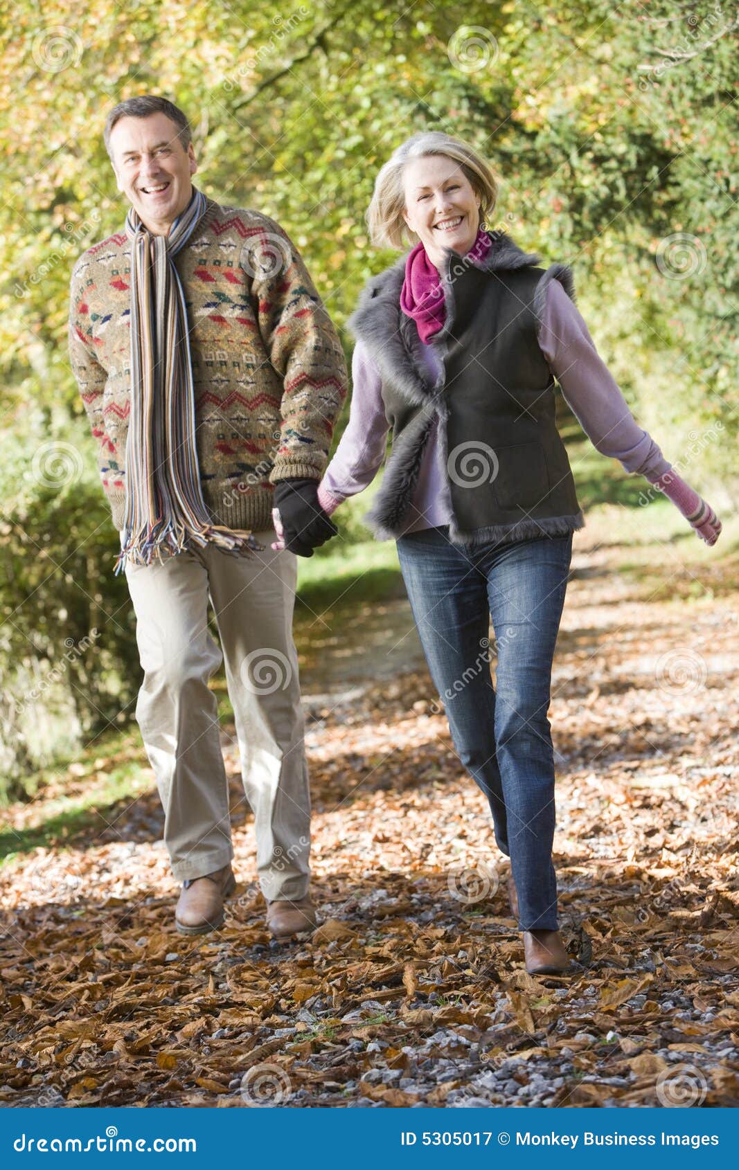 senior couple walking through autumn woods