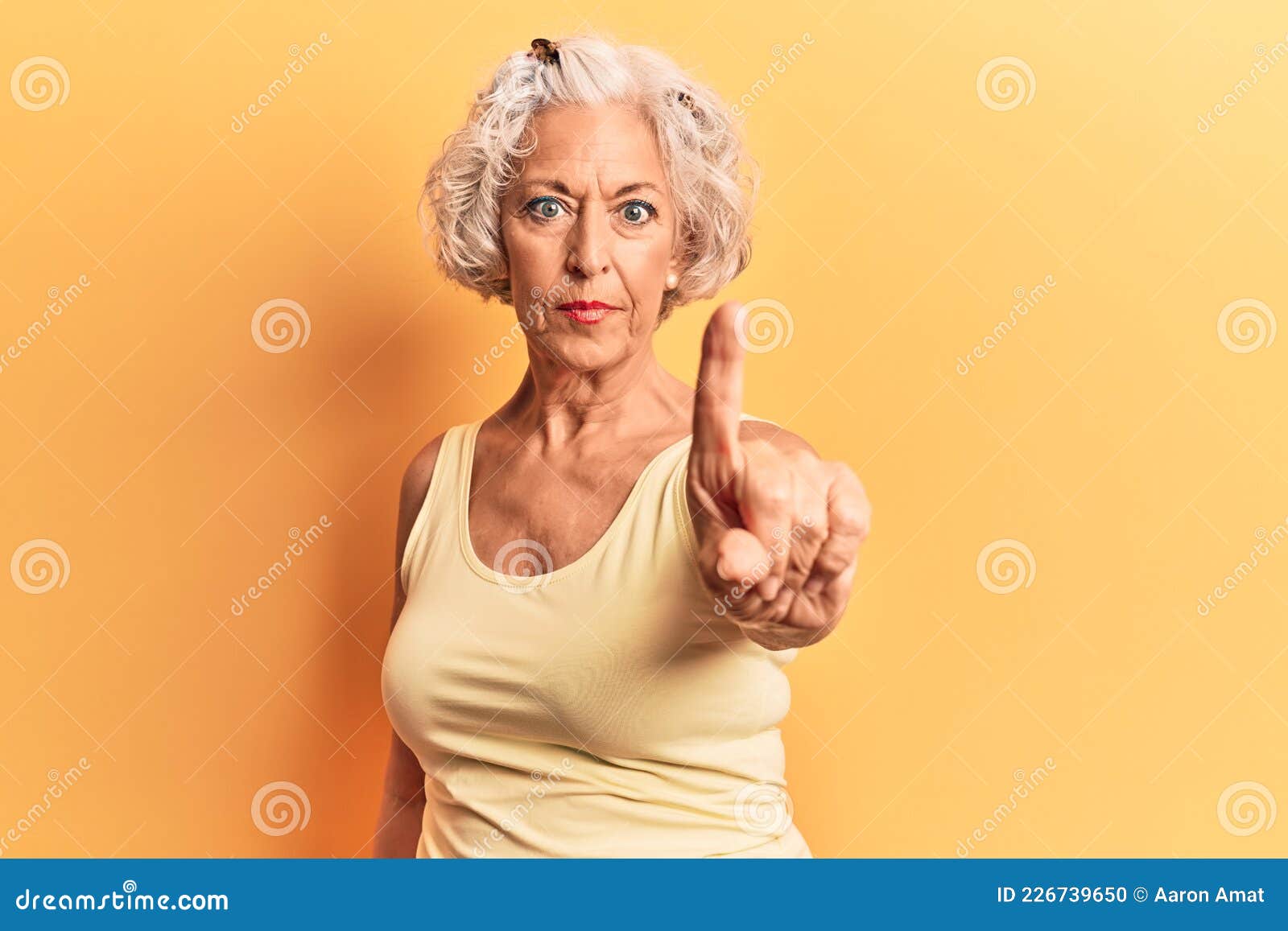 senior grey-haired woman wearing casual clothes pointing with finger up and angry expression, showing no gesture