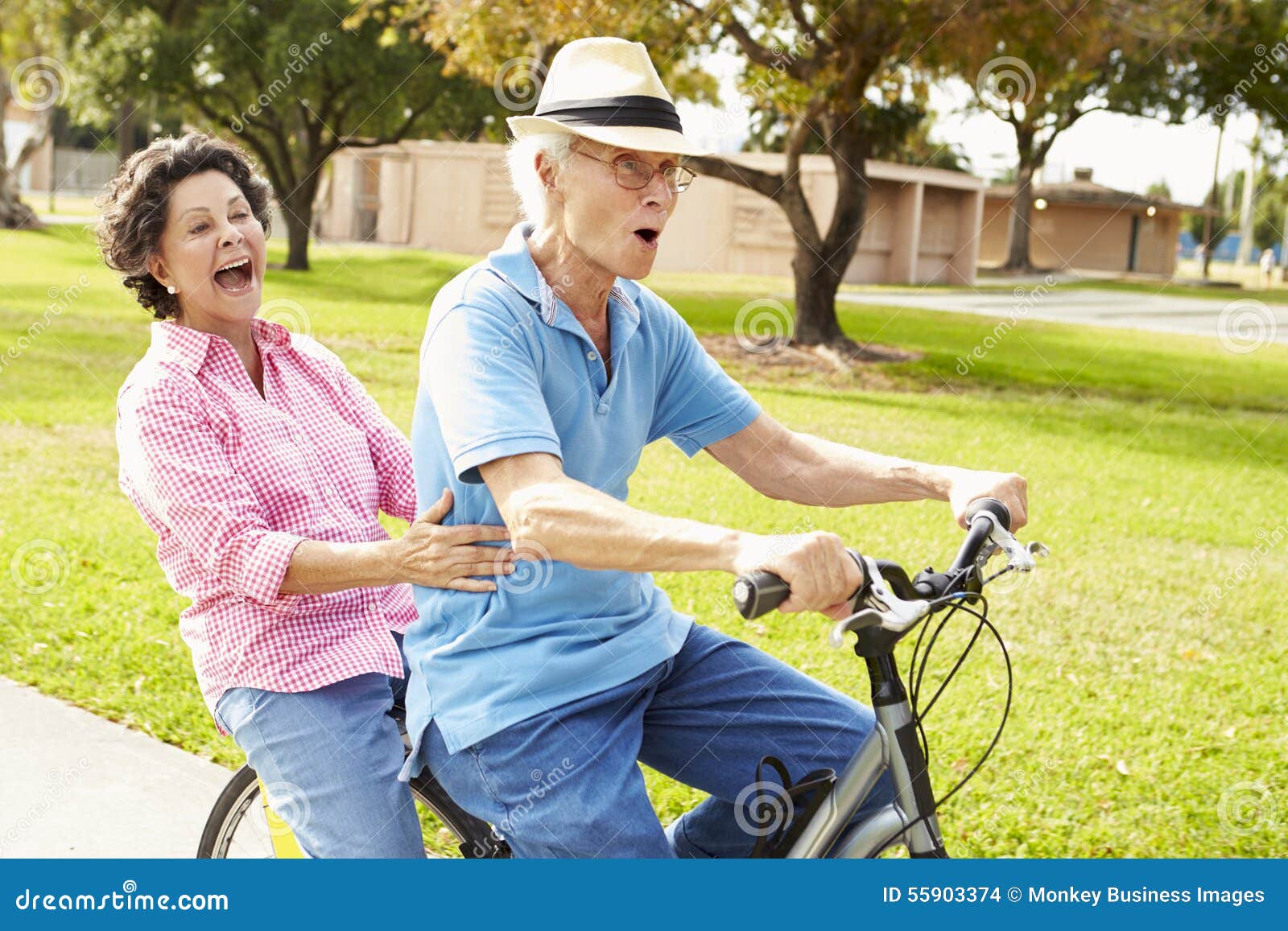 senior hispanic couple riding bikes in park