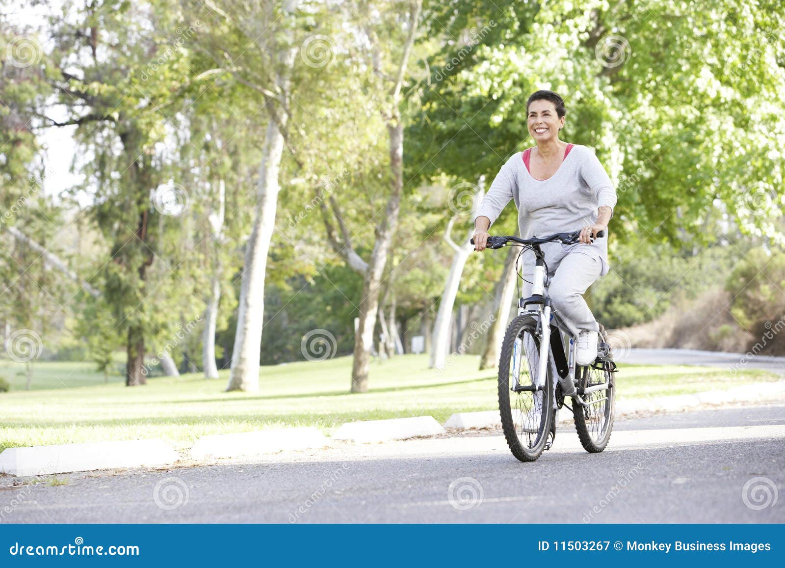 senior hispanic woman cycling in park