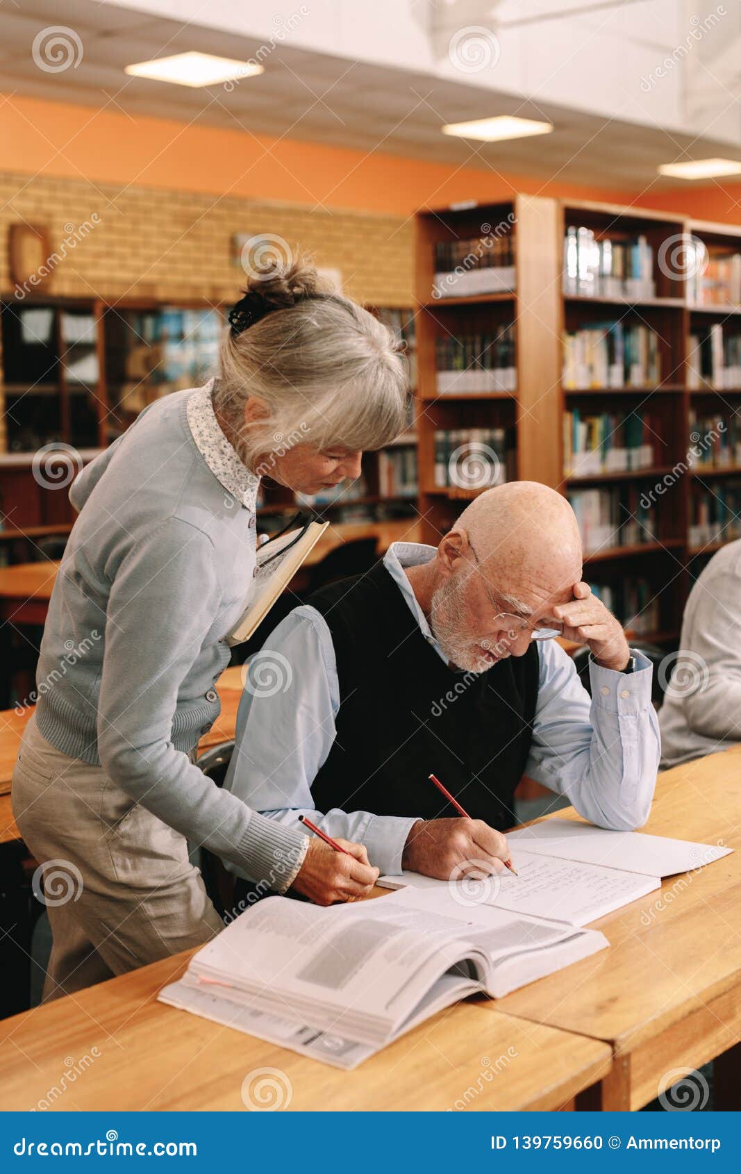 Senior Lecturer Helping an Elderly Man in University Class Stock Photo