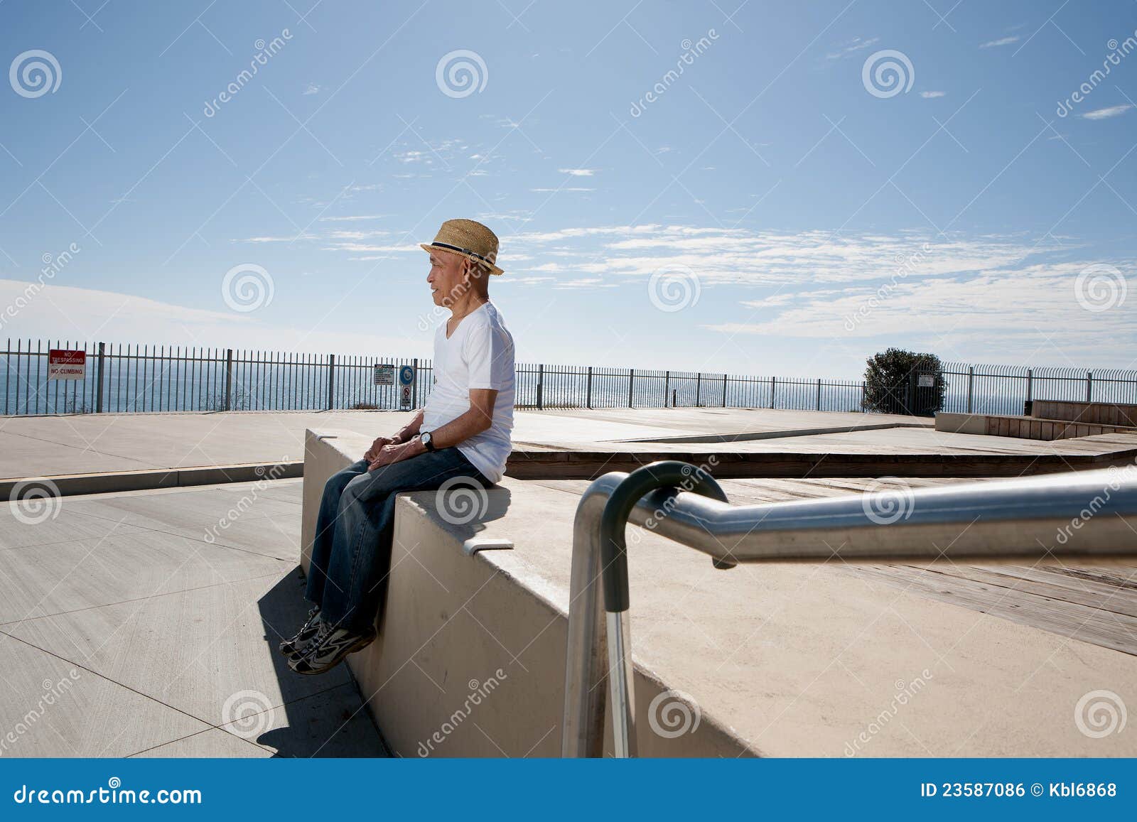 Senior man sitting on oceanview site and watching sea