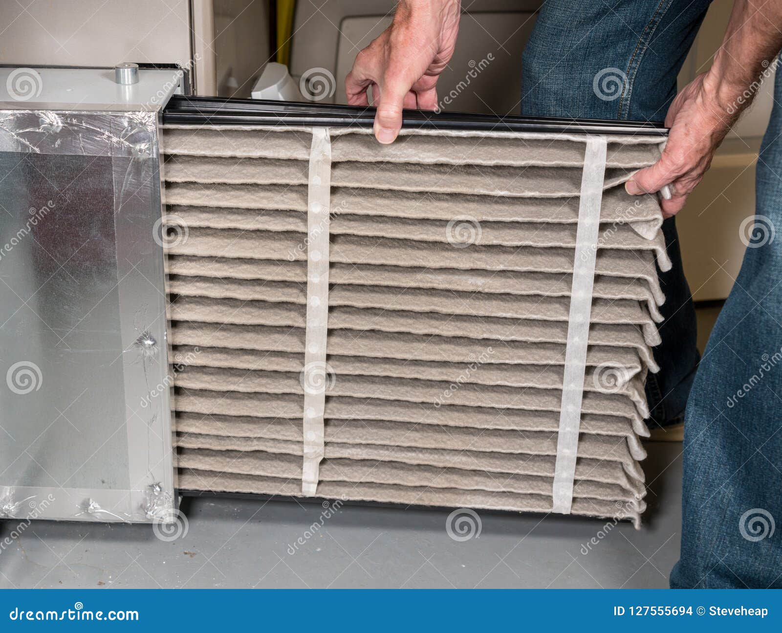 senior man changing a dirty air filter in a hvac furnace