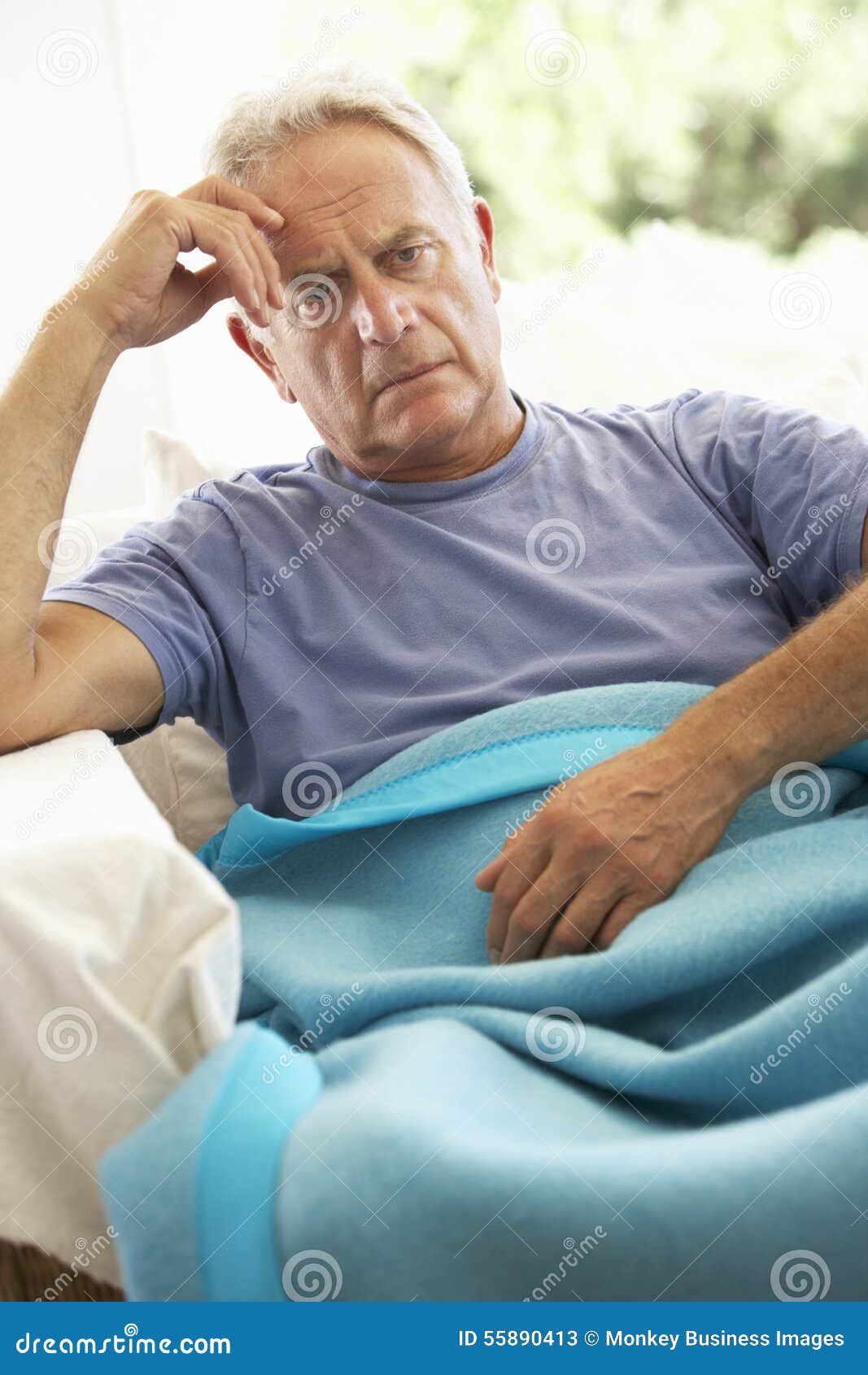 senior man feeling unwell resting under blanket