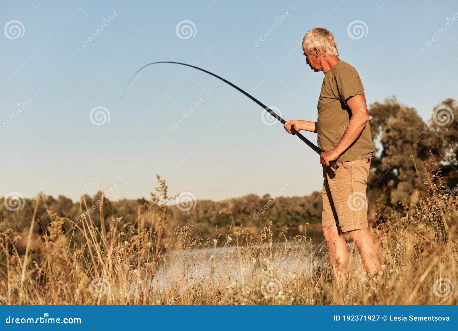 Senior Man Fishing, Holding Fishing Pole in Hands, Wearing Green T Shirt  and Short, Looking at Bobber and Pulling Out Fish, Stock Image - Image of  enjoying, breakwater: 192371927