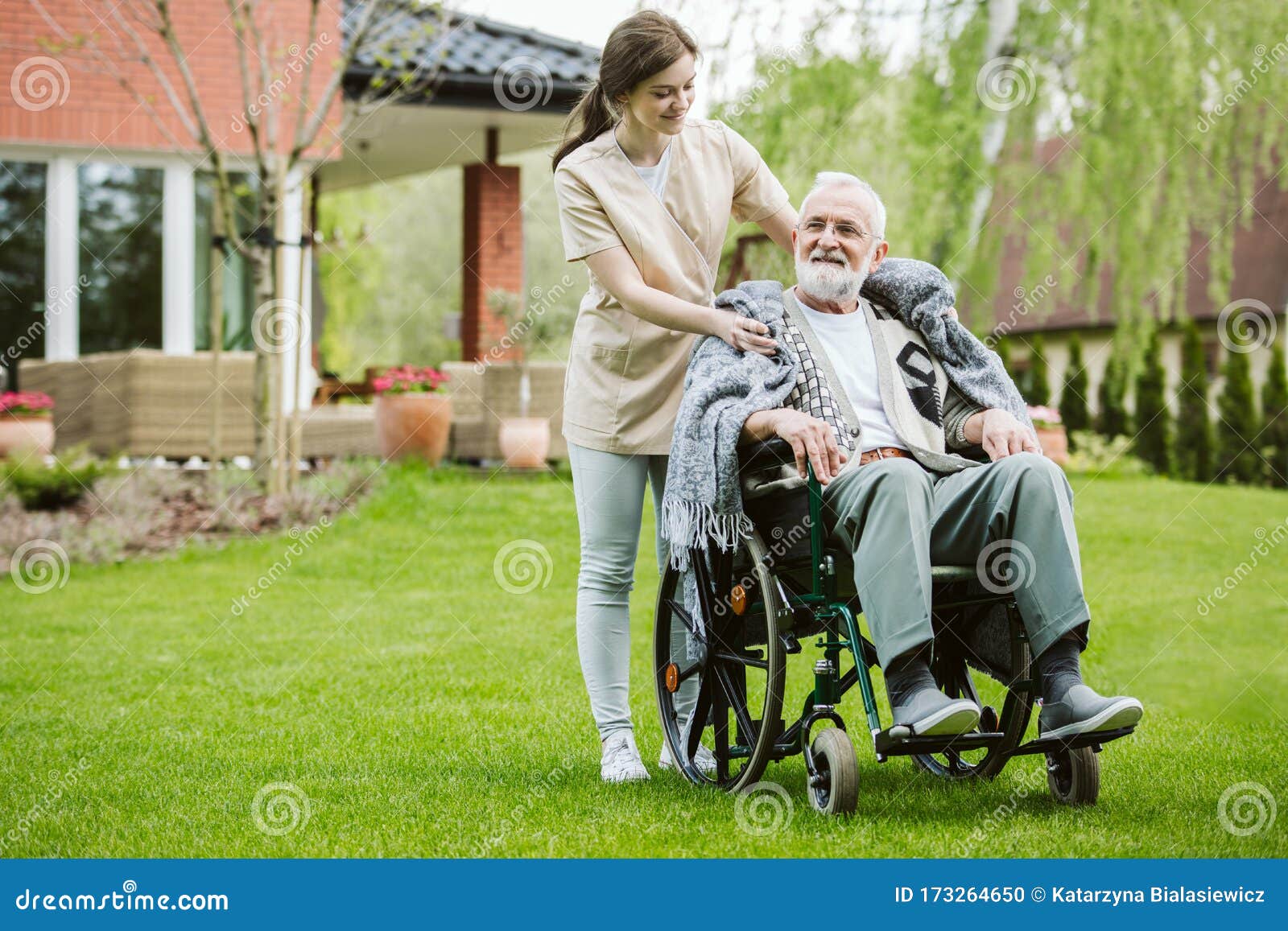 senior with helpful volunteer in the garden of professional care home