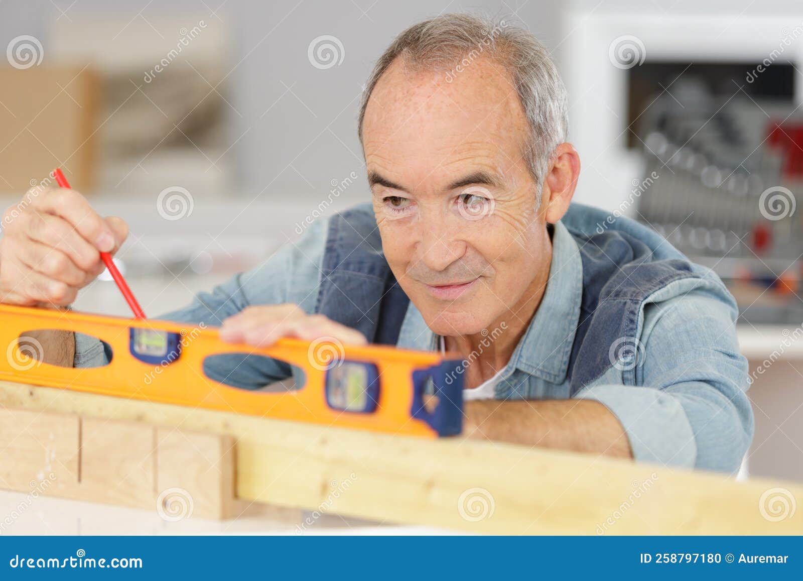 Senior Man Measuring Wall with Construction Level Stock Photo Image