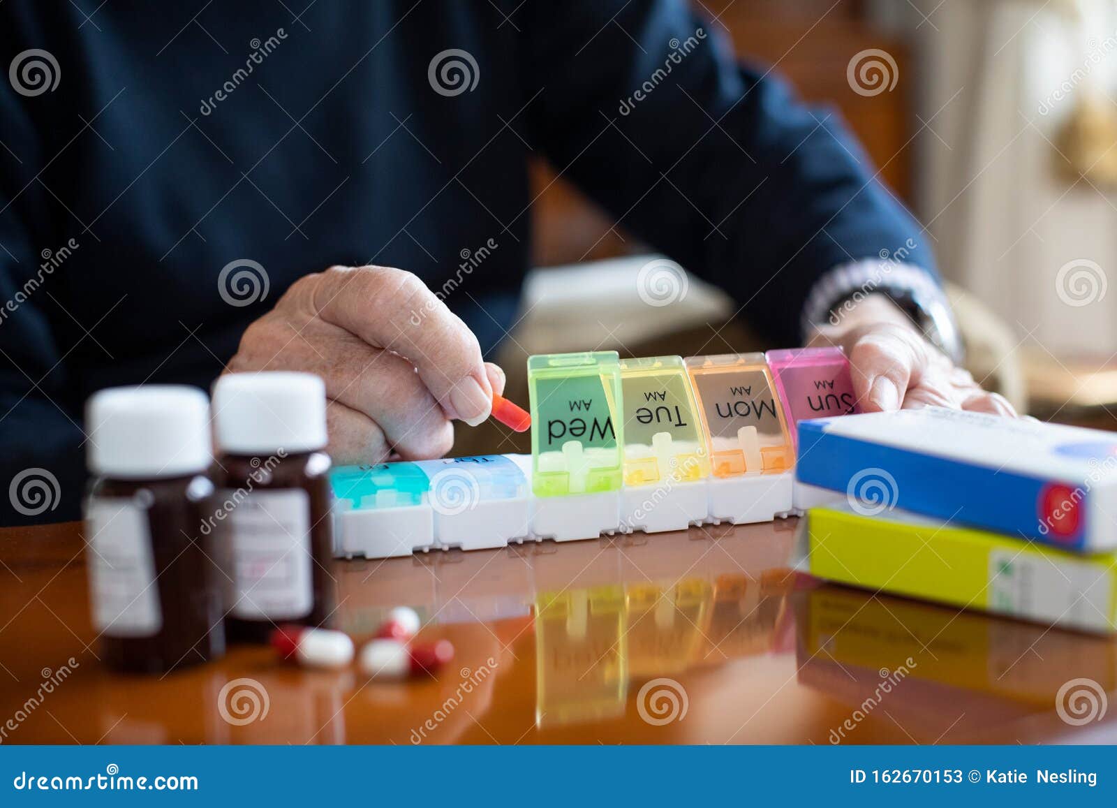close up of senior man organizing medication into pill dispenser